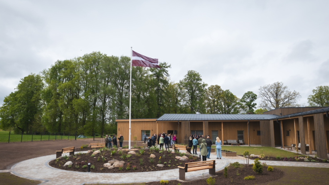 Pansija Rauna no ārpuses. Būna māja, priekšā plīvo Latvijas karogs
