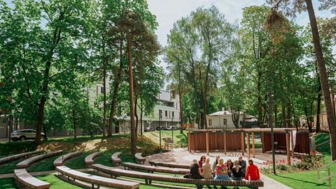 Ārtelpas amfiteātra tipa zona zaļā, koku ieskautā parkā.