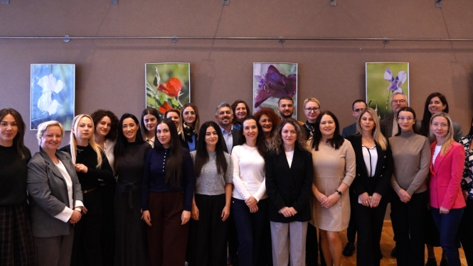 Starptautiskas mācību vizītes dalībnieki pozē kopīgai grupas fotogrāfijai konferenču telpā. 